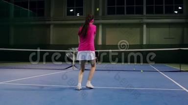 一个穿着粉红色T恤和白色裙子的女人在网球比赛中<strong>打球</strong>。 网球运动员学会<strong>打球</strong>